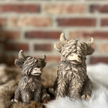 Set van 2 stenen hooglanders zittend