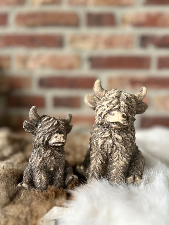 Set van 2 stenen hooglanders zittend