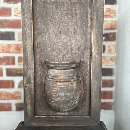 Houten wandpaneel met vaas op voet