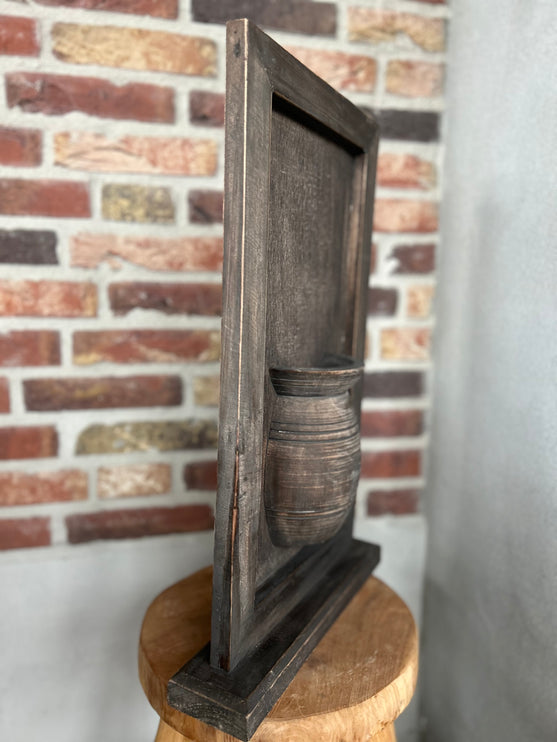 Houten wandpaneel met vaas op voet